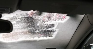 Ön camı tırmalayan kadın, arabadan kar temizleyen kadın, kar fırçasıyla ön camdan kar temizleyen kadın.