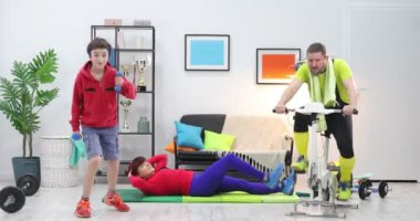 Mutlu aile evde spor egzersizleri yapıyor. Anne, baba ve oğul evde birlikte antrenman yapıyorlar.