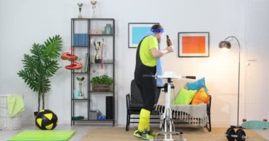 Evde spor aletleri olan tembel sarhoş bir adam. Sportmen olmayan adam bisikletini evde çalıştırıyor. Komik spor