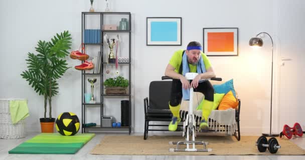 Ung Mand Atlet Stationær Cykel Udøver Derhjemme Fitness Parodi Humor – Stock-video