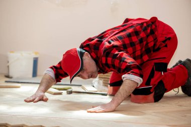 Tamirci ahşap döşeme döşeme döşemesi döşeme işçisi. İşçi ahşap kaplama döşeme kuruyor. Parke ve marangoz konsepti,