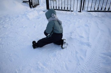Çocuk kışın dışarıda oynuyor.