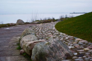 Deniz kenarında taş döşeli bir yol.