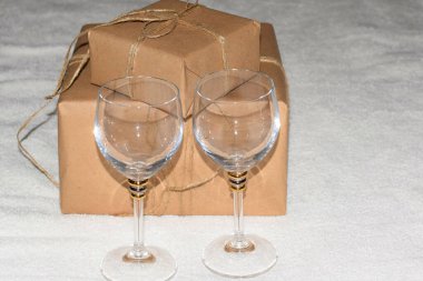 Bir ip yay ve iki şarap kadehiyle el işi kağıdında hediye kutusu.