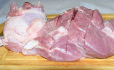 Tahtada domuz eti dilimlenmiş.