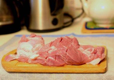 Tahtada domuz eti dilimlenmiş.