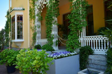 Parktaki binanın ön cephesi, bir yaz günü, insanların dinlenebileceği bir yer.