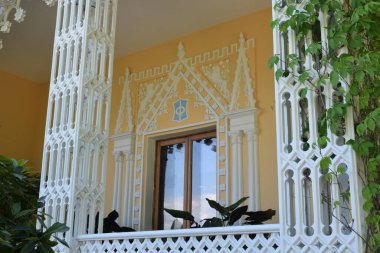 Parktaki binanın ön cephesi, bir yaz günü, insanların dinlenebileceği bir yer.