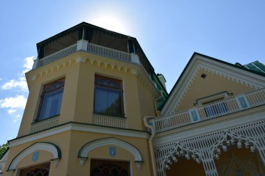 Parktaki binanın ön cephesi, bir yaz günü, insanların dinlenebileceği bir yer.