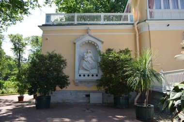 Parktaki binanın ön cephesi, bir yaz günü, insanların dinlenebileceği bir yer.