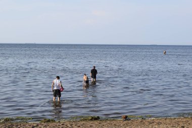 İnsanların plajında, denizde, kumsalda eğlence.