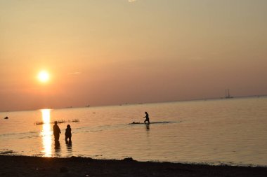 Sahilde insanlar, sahilde gün batımı, deniz...