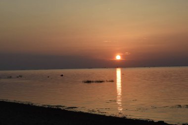 Sahilde gün batımı, deniz
