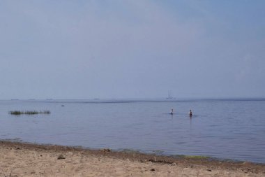 Kumsalda ve kumsalda dinleniyor.