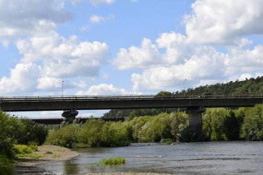 Nehir, yeşil kıyılar, bulutlu gökyüzü