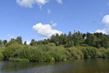 Nehir, yeşil kıyılar, bulutlu gökyüzü