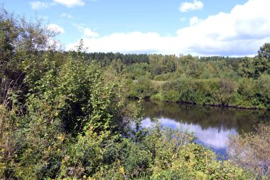 Nehir, yeşil kıyılar, bulutlu gökyüzü