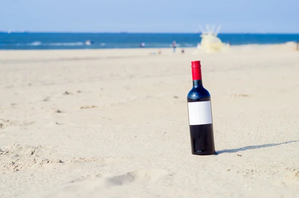 Une bouteille de vin sur la plage, romance près de la mer Images De Stock Libres De Droits