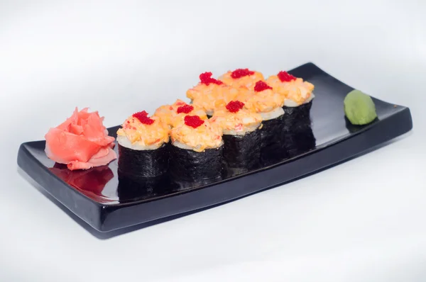 Zencefil ve siyah bir plaka üzerinde wasabi ile pişmiş suşi