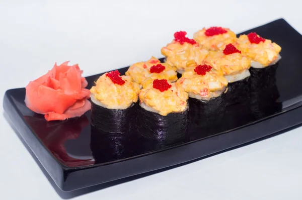 Zencefil ve siyah bir plaka üzerinde wasabi ile pişmiş suşi