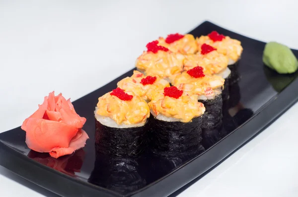 Zencefil ve siyah bir plaka üzerinde wasabi ile pişmiş suşi