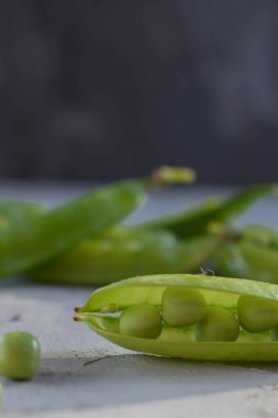 Ön planda tanecikler olan taze bezelye kabuğu makro fotoğrafçılığı kopyalamak için bir alandır.