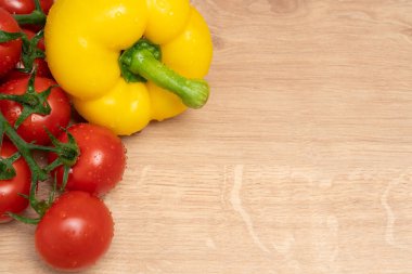 Sarı dolma biber ve sulu domateslerin yakın çekimi, sağlıklı beslenme kavramının reklamını yapmak için tahtayı kopyalamak üzerinedir.