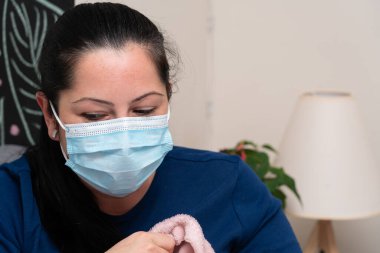 Grip virüsü enfeksiyonunun belirtilerini önlemek için cerrahi ya da tıbbi tek kullanımlık maske takan hasta kadınların yakın çekimleri.