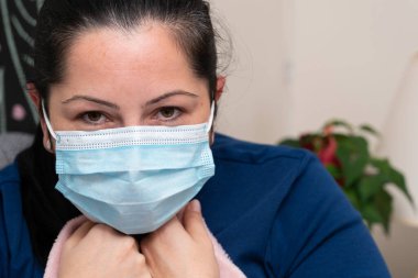 Grip ya da kovid19 virüs enfeksiyonuna yakın çekim. Hasta yetişkin kadın modeli grip salgını olarak tek kullanımlık cerrahi veya tıbbi koruyucu maske takıyor.