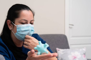 Sağlıksız yetişkin kadın modeli salgın sırasında enfeksiyonu önlemek için tek kullanımlık cerrahi veya tıbbi maske takan sahte koronavirüs taklidi yapıyor.