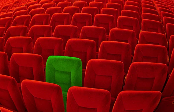 Ein grüner Stuhl inmitten zahlloser roter Sitzgelegenheiten — Stockfoto