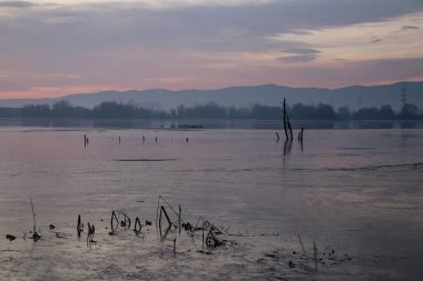 Ocak ayında donmuş bir gölün üzerinde romantik bir gün doğumu