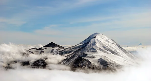 Picos de montanhas acima das nuvens, Rússia, Kamchatka Fotos De Bancos De Imagens