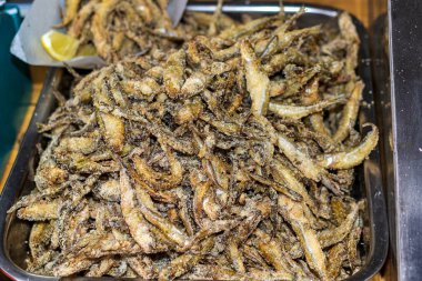 Bir sürü taze pişmiş balık metal bir konteynırda. Sokak yemeklerinde, etkinliklerde, festivallerde sunulan açık ateşte nefis yemekler..