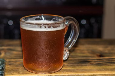 Hafif bira ve kahverengi ahşap arka planda beyaz köpüklü cam bardak. Alkolik içki. Taze bira. Kopyalama alanı ile. 