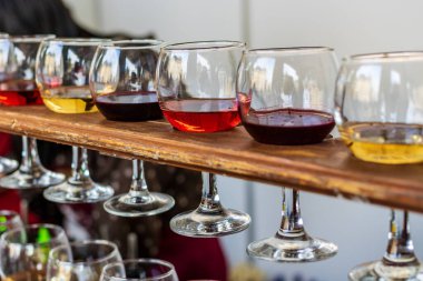 Kırmızı, gül ve beyaz şarap. Şarabın çeşitli çeşitleri, renkleri ve tonları. Şeffaf şarap kadehleri. Bulanık arkaplan.