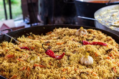 Sağlıklı bir sokak yemeği - büyük bir kazan sıcak pilav içinde et parçaları ve sıcak kırmızı biberle birlikte. Sokak yemeklerinde, etkinliklerde, festivallerde sunulan açık ateşte nefis yemekler..