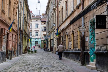 Lviv, Ukrayna - 25 Ekim 2020 Lviv 'in tarihi merkezinde patikası olan dar bir kaldırım taşı caddesi. Sokak sahnesi. Eski şehrin sokakları ve mimarisi.