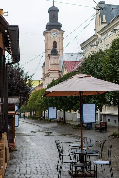 Uzhhorod, Ukrayna. Uzhorod 'un tarihi merkezinde dar, kaldırımlı bir cadde. Coronavirus' la mücadele sırasında hiçbir ziyaretçisi ve boş reklam panoları olmayan bir sokak kafesi..