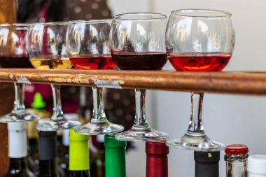 Kırmızı, gül ve beyaz şarap. Şarabın çeşitli çeşitleri, renkleri ve tonları. Şeffaf şarap kadehleri. Bulanık arkaplan.