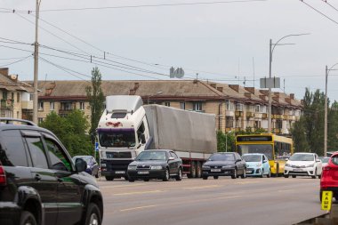 Kyiv, Ukrayna - 30 Haziran 2021: Yoğun bir şehir otoyolunun ortasında bozuk büyük bir kamyon durdu. Arabalar yolun ortasında duran bir kamyonun etrafında dolaşır..