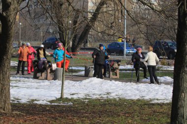 Kyiv Ukrayna - 4 Mart 2021: Bir şehir parkında aktif bir grup kadın hafif spor egzersizleri yapıyor. 50 yaş üstü insanlar için kış eğitimi. Spor, yoga ve sağlıklı yaşam tarzı konsepti.