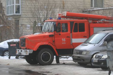 Kyiv Ukrayna - Şubat 03: 2021: Bir apartmandaki yangını söndürmede kırmızı bir itfaiye aracı yer alıyor. İtfaiye aracı park halindeki arabaların yakınındaki yüksek binaların bahçesinde park halinde..
