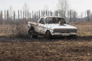 Kyiv Ukrayna - 10 Ocak 2021: Retro otomobil GAZ 24 Volga şehir dışında bir köy yolunda. 1980 'de Sovyetler Birliği' nde üretilen paslı eski bir araba..
