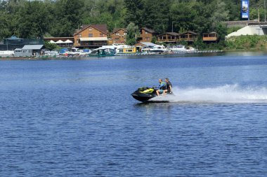 Kyiv Ukrayna, Dinyeper Nehri - 12 Haziran 2020: Geniş bir nehirde jet ski süren iki yetişkin adam. Su motosikleti aktif yaz tatili konsepti.