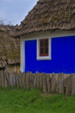 Kyiv. Pirogovo. Ukrayna - 02 Mayıs 2021: Samandan çatılı geleneksel Ukrayna eski evi. Ulusal mimari. Ilık bahar güneşli gün.