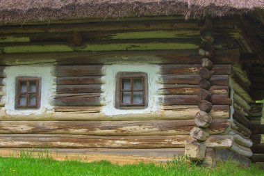 Kyiv. Pirogovo. Ukrayna - 02 Mayıs 2021: Sazdan çatılı geleneksel bir Ukrayna antik evinin parçası. Tek katlı binalar. Ulusal mimari. Ilık bahar güneşli gün.