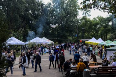 Korosten 'Ukrayna - Eylül 04 2021: Şehir parkında patatesli gözleme festivali. Bir grup insan çeşitli yiyeceklerle çadırların arasında yürüyor. Gastro festivalinde aşçılık ürünleri tatmak..