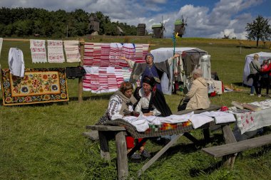 Kyiv, Ukrayna - 5 Eylül 2021: Açık Hava Geleneksel El Sanatları Fuarı. Ulusal Ukrayna giysileri. Uzun tezgahlarda çeşitli el sanatları sergileniyor. Ziyaretçiler eşsiz ürünlere göz atar ve onları seçer.