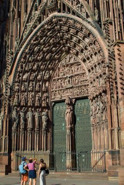 Strasbourg, Fransa - 25 Ağustos 2025: Strasbourg, Fransa 'da muhteşem Strasbourg Katedrali büyük Gotik ihtişamıyla yükseliyor. Karmaşık taş oymaları ve yükselen portalı İncilsel hikayeler anlatıyor..